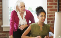 career coach looking over a students shoulder
