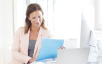 woman at a desk reading files