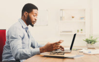 A young man researches a potential employer to ensure it isn't fraudulent.
