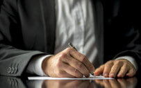 Person writing with pen and paper