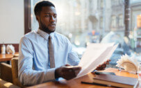 man sitting at a desk reading some papers