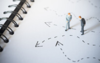 two figurines on a page with directional lines