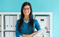 woman smiling while holding a binder