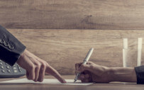 close up of people's hands reviewing a document